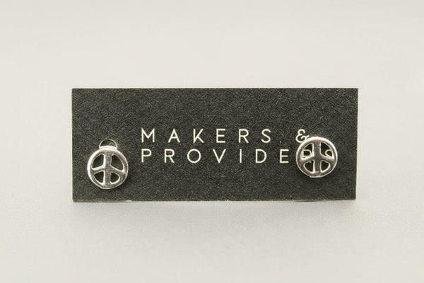 Silver peace sign earrings on a 'Makers & Provide' card against a white background