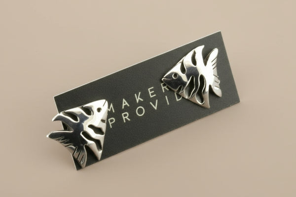 Silver fish-shaped pins on a black card with 'Maker Provide' branding on a gray background