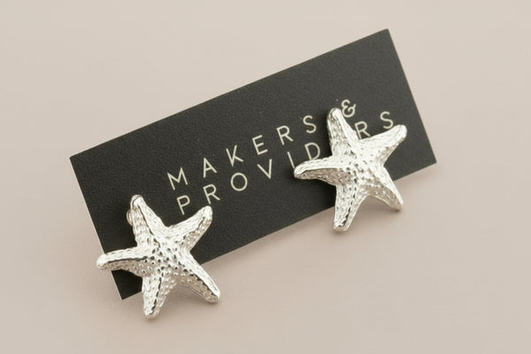 Starfish-shaped earrings on a card with 'Makers & Providers' text against a gray background