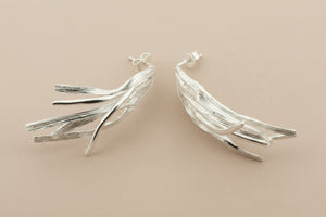 Silver leaf-shaped earrings on a dark gray background