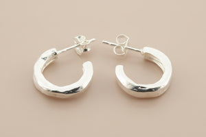 Pair of silver hoop earrings on a gray background