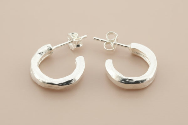 Pair of silver hoop earrings on a gray background