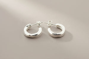Pair of silver hoop earrings on a gray background