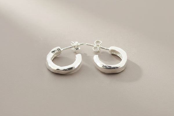 Pair of silver hoop earrings on a gray background