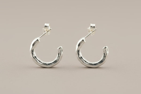 Silver hoop earrings on a gray background