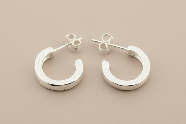 Pair of silver hoop earrings on a gray background