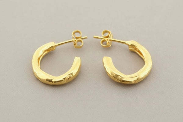 Gold hoop earrings on a gray background