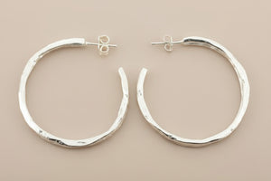 Pair of silver hoop earrings on a gray background