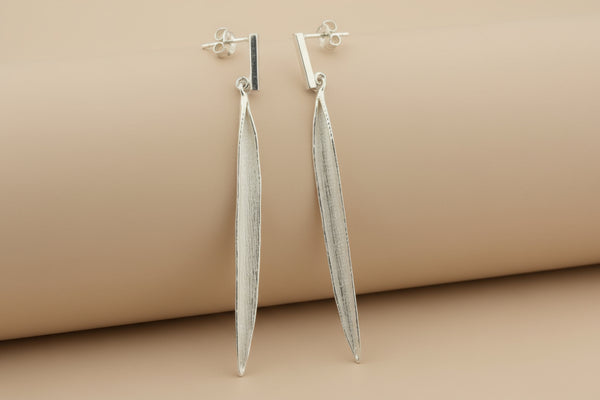 Pair of silver earrings on a gray background