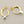 Load image into Gallery viewer, Gold and silver hoop earrings on a gray background
