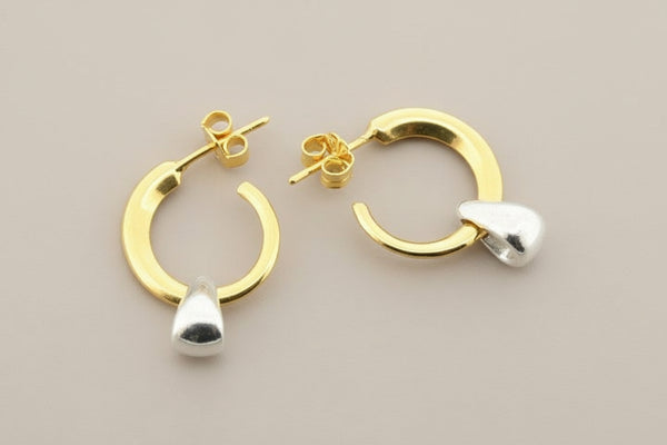 Gold and silver hoop earrings on a gray background