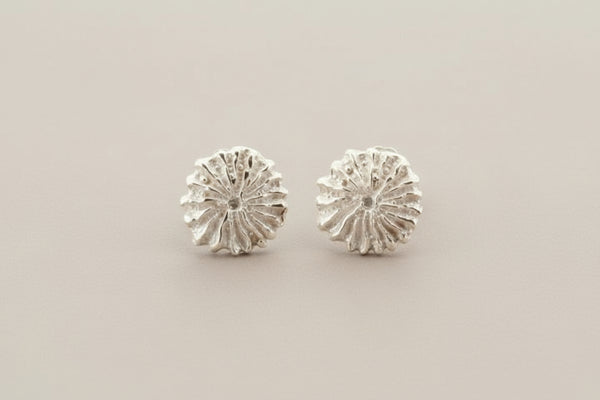 Pair of silver floral stud earrings on a gray background