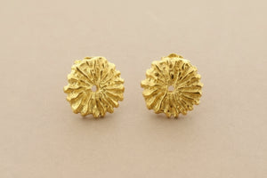Pair of gold floral earrings on a gray background