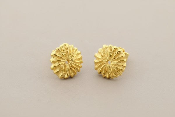 Pair of gold floral earrings on a gray background