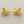 Load image into Gallery viewer, Gold fish-shaped earrings on a gray background
