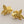 Load image into Gallery viewer, Gold fish-shaped earrings on a gray background
