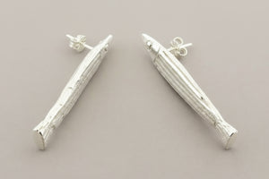 Silver fish-shaped earrings on a gray background