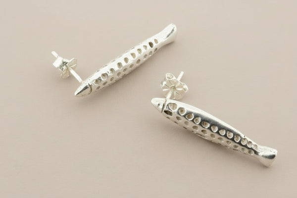 Pair of silver earrings on a gray background