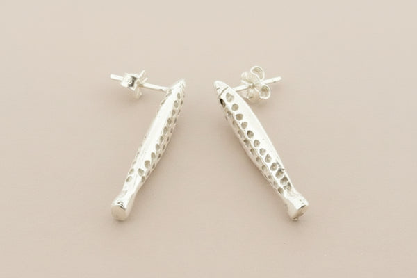 Pair of silver earrings on a gray background