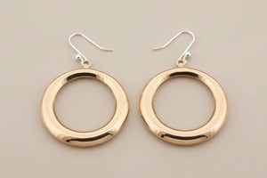 Copper hoop earrings on a gray background