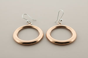 Copper hoop earrings on a gray background