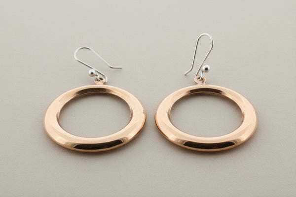 Copper hoop earrings on a gray background