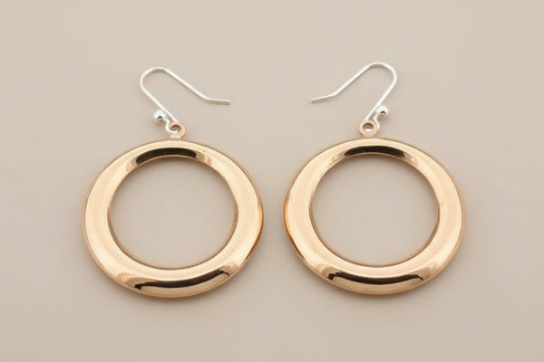 Copper hoop earrings on a gray background