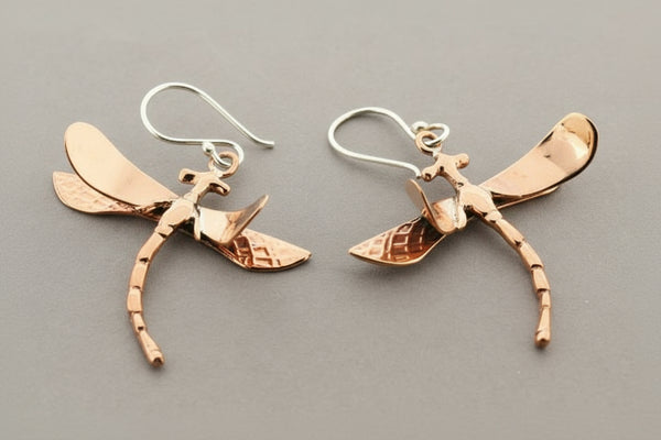 Dragonfly-shaped earrings on a gray background