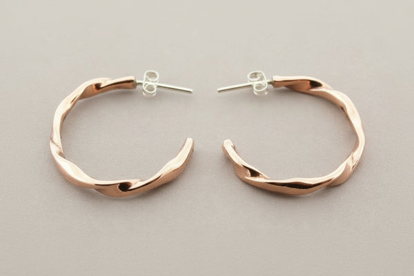 Copper hoop earrings on a gray background