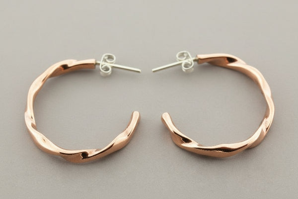 Rose gold hoop earrings on a gray background