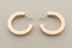 Copper hoop earrings on a gray background