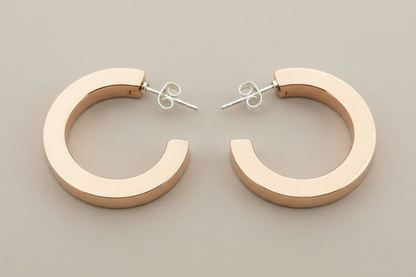 Copper hoop earrings on a gray background