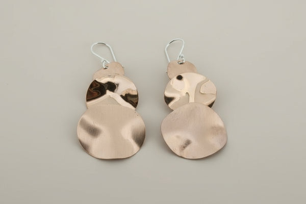 Pair of copper earrings on a dark background