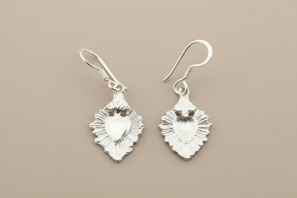 Pair of silver heart-shaped earrings on a gray background