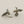 Load image into Gallery viewer, Pair of silver bird-shaped earrings on a gray background
