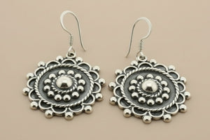 Pair of silver earrings on a gray background