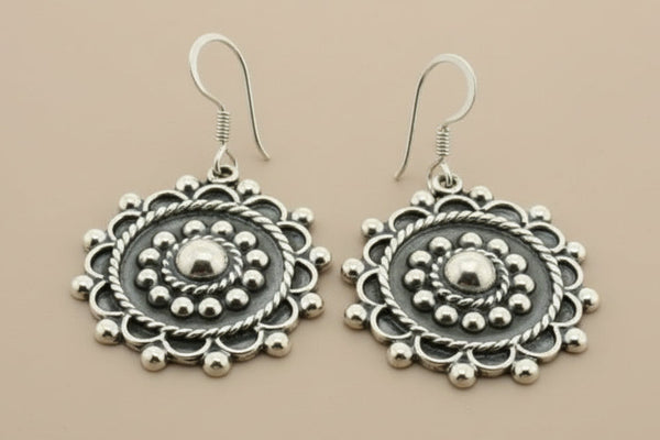Pair of silver earrings on a gray background