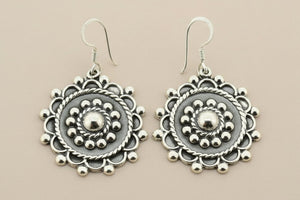 Pair of silver earrings on a gray background