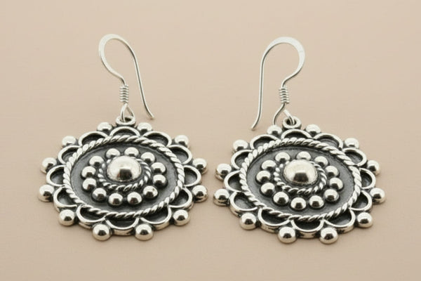 Pair of silver earrings on a gray background