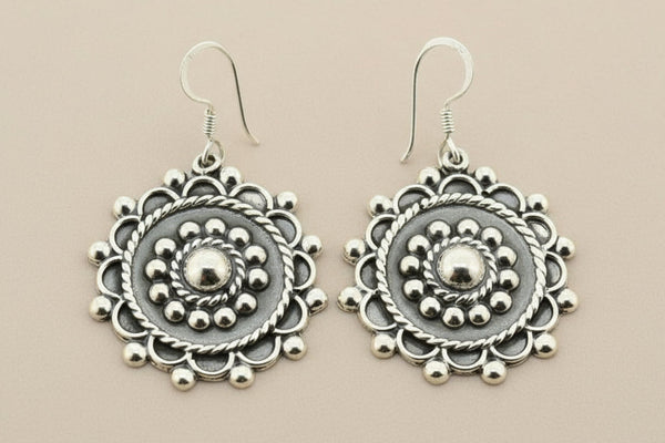Pair of silver earrings on a gray background