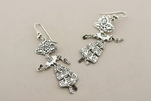 Silver earrings on a gray background