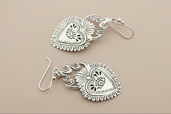 Pair of silver earrings on a dark gray background