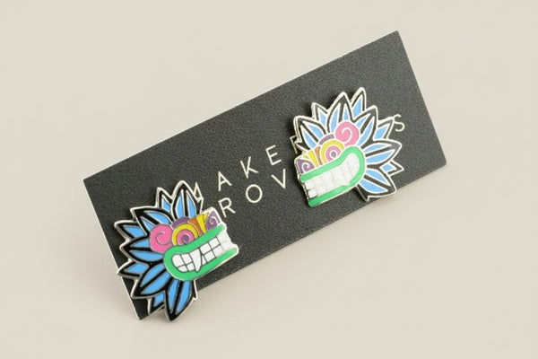 Two colorful enamel pins on a black card with 'Makers Row' branding.