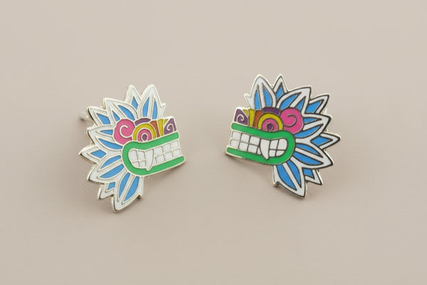 Pair of colorful mask-shaped earrings on a gray background