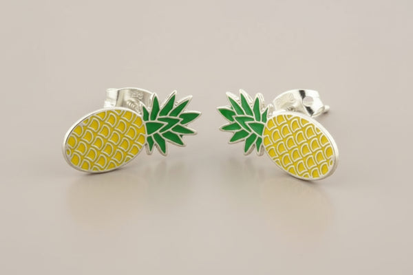 Pineapple-shaped earrings on a gray background