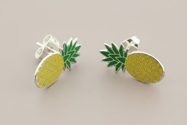 Pineapple-shaped earrings with green and yellow details on a gray background