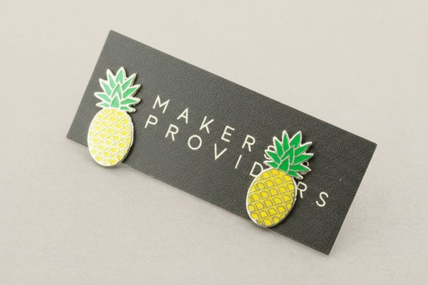 Pineapple-shaped earrings on a 'Maker Providers' card against a gray background
