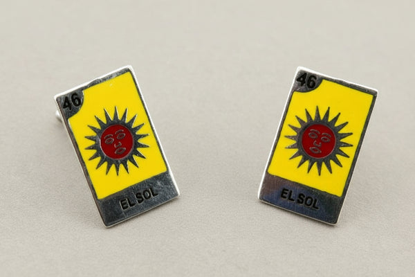 Pair of 'El Sol' themed earrings on a gray background