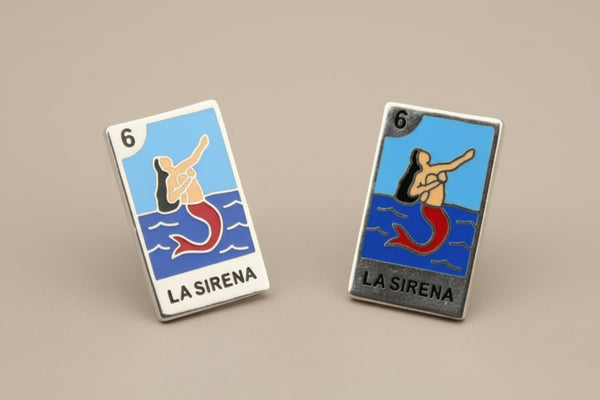 Pair of 'La Sirena' earrings on a gray background
