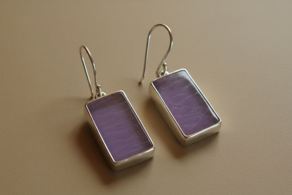 Pair of purple rectangular earrings on a light gray background